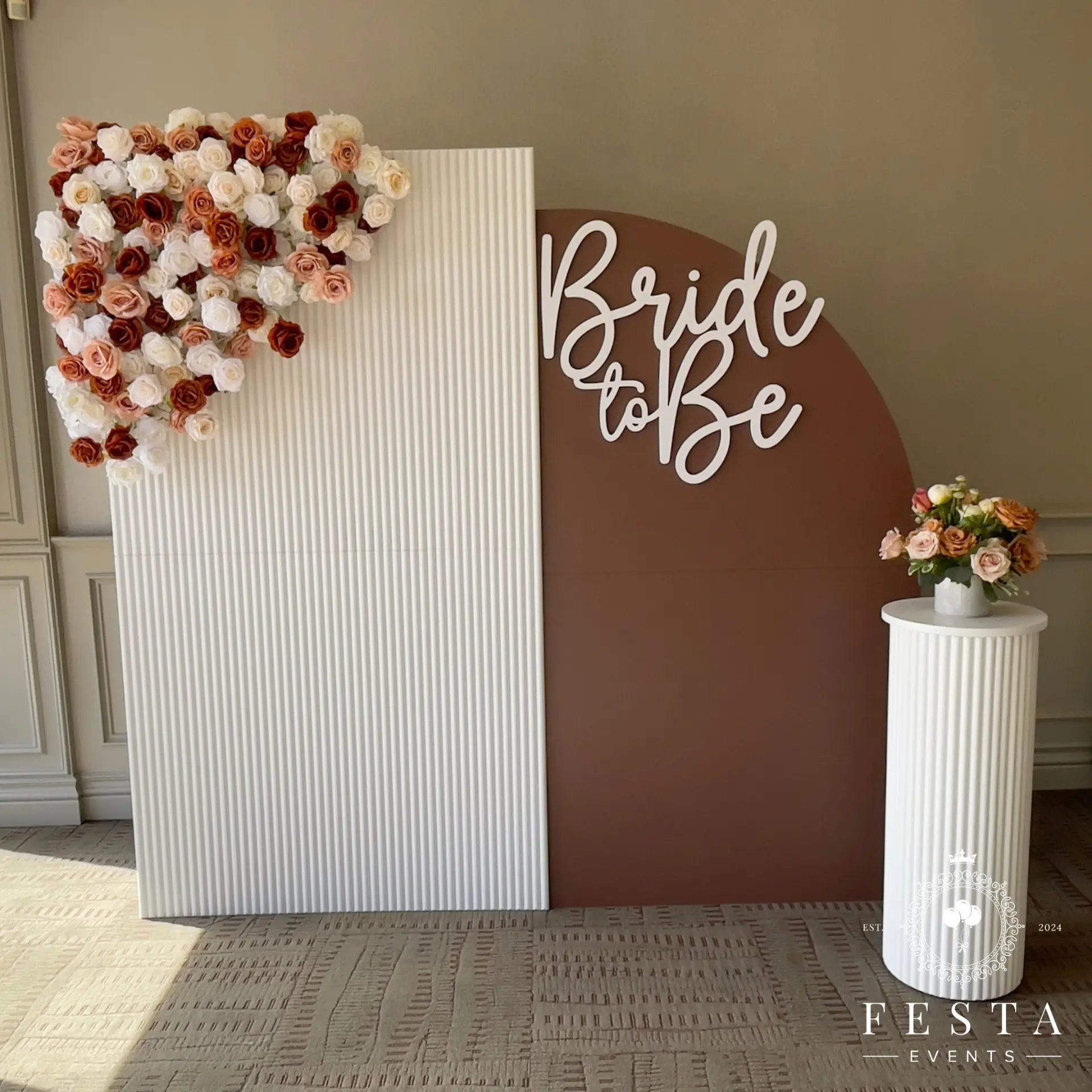 Bride to Be backdrop with a floral heart arrangement and ribbed white panels